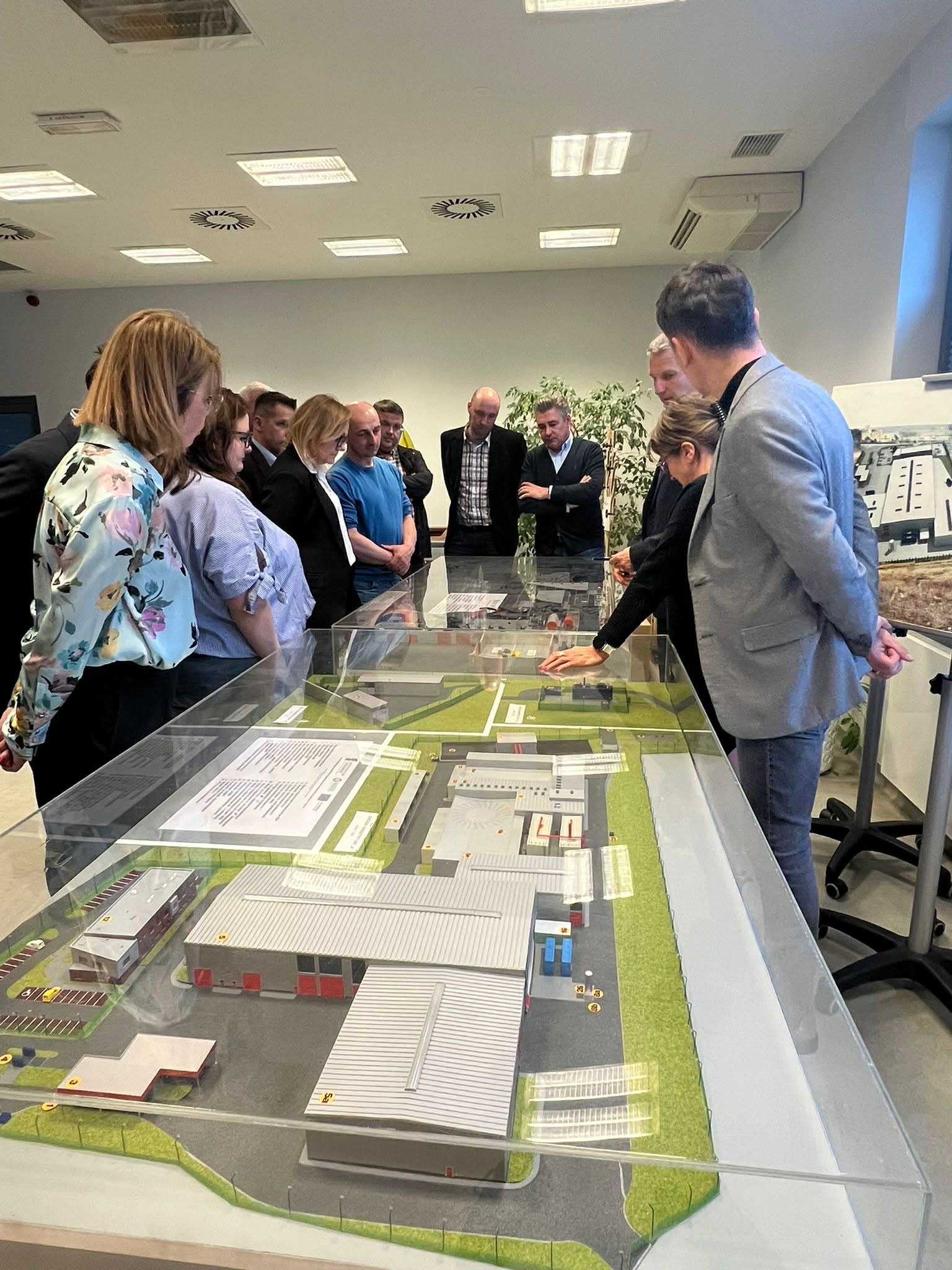 Osoby z pomieszczeniu, ogladający makietę 