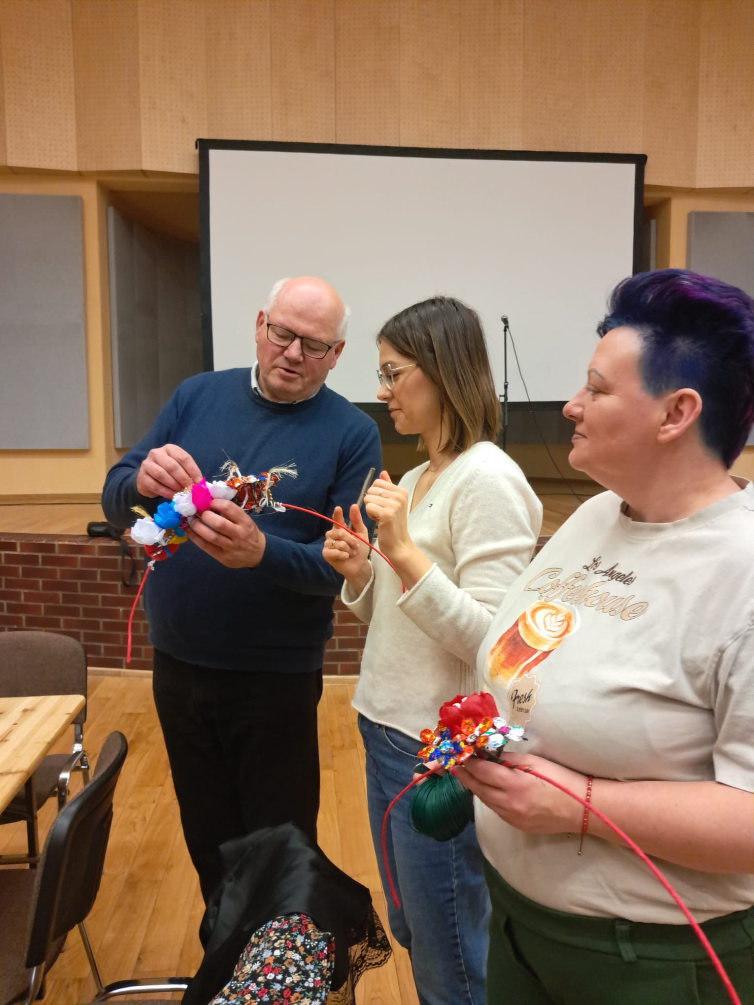 Dwie kobiety i mężczyzna w pomieszczeniu. Tworzą galandę