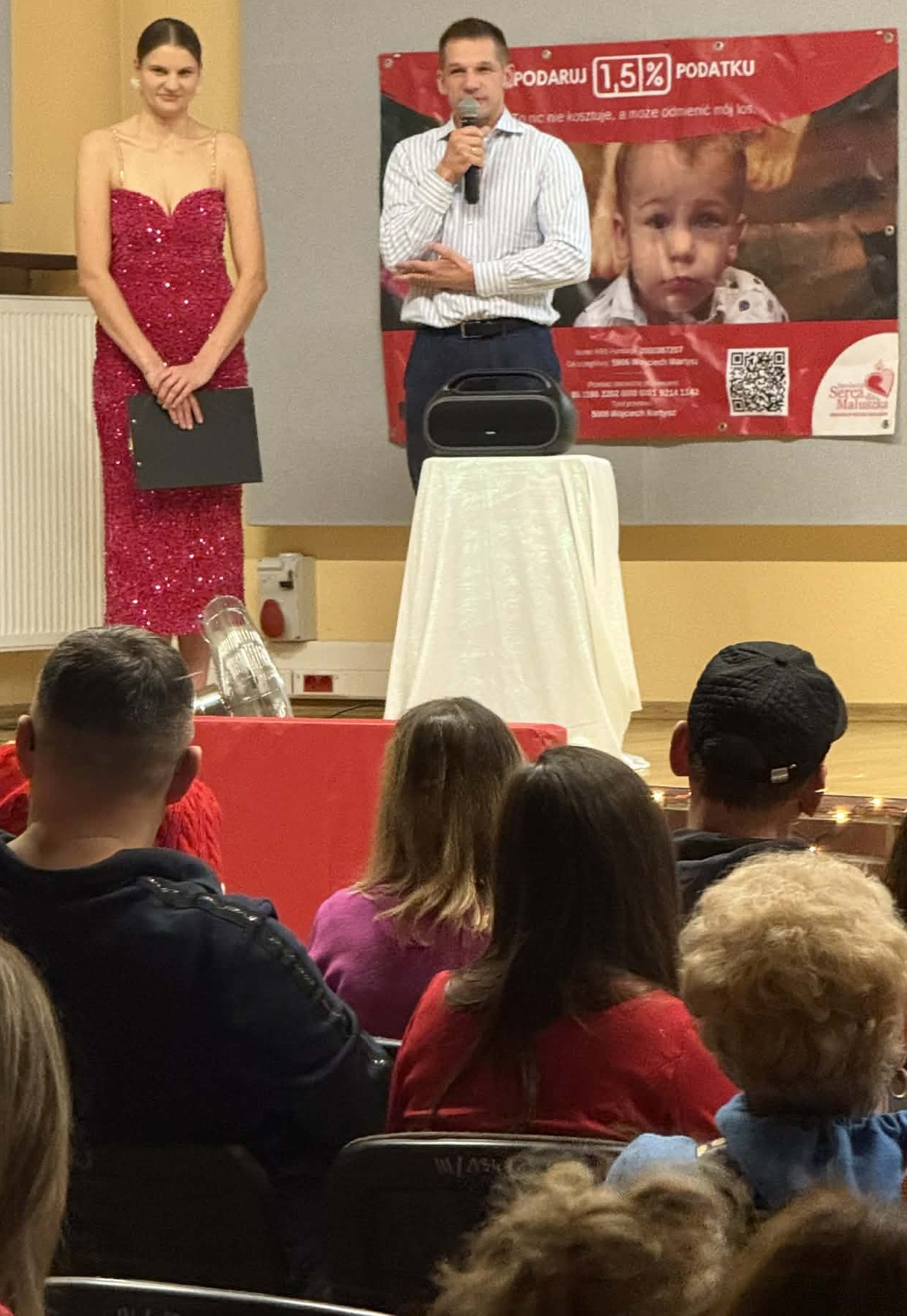 Kobieta i mężczyzna przemawiający na scenie. 