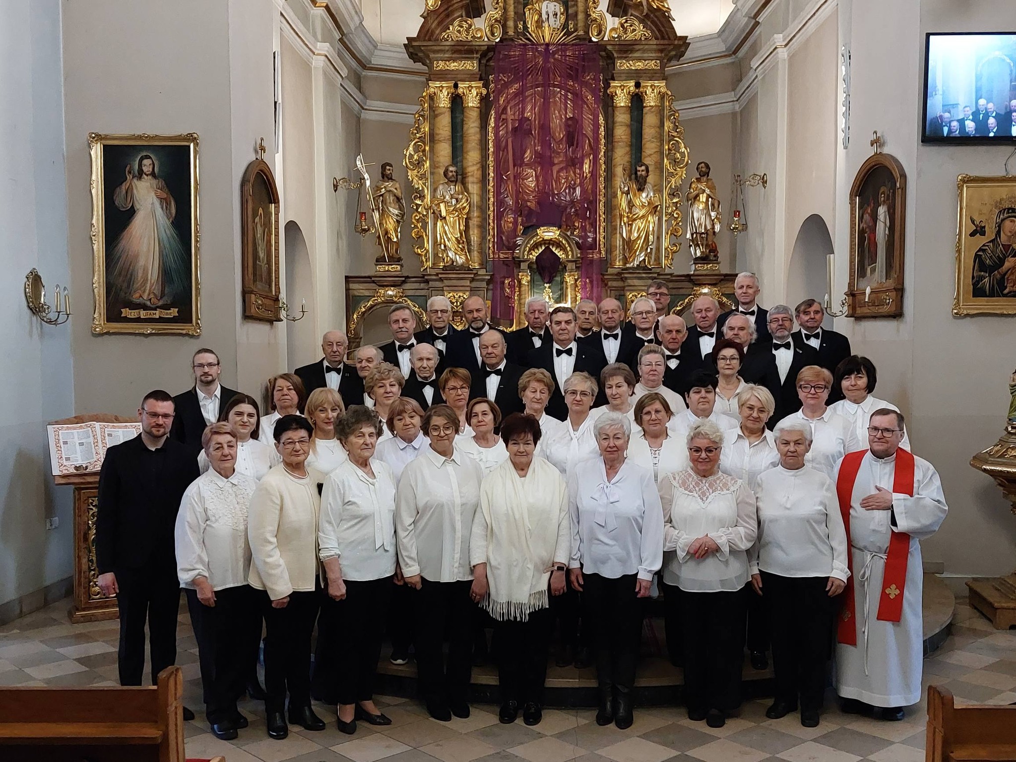 Kobiety i mężczyźni pozujący do zdjęcia na tle ołtarza w kościele