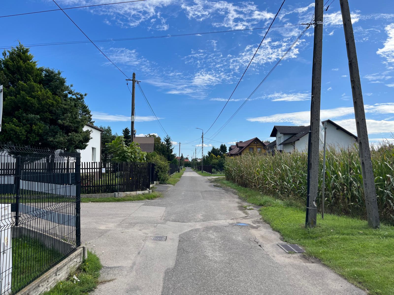 Ulica z infrastrukturą przebiagająca pomiędzy domami 