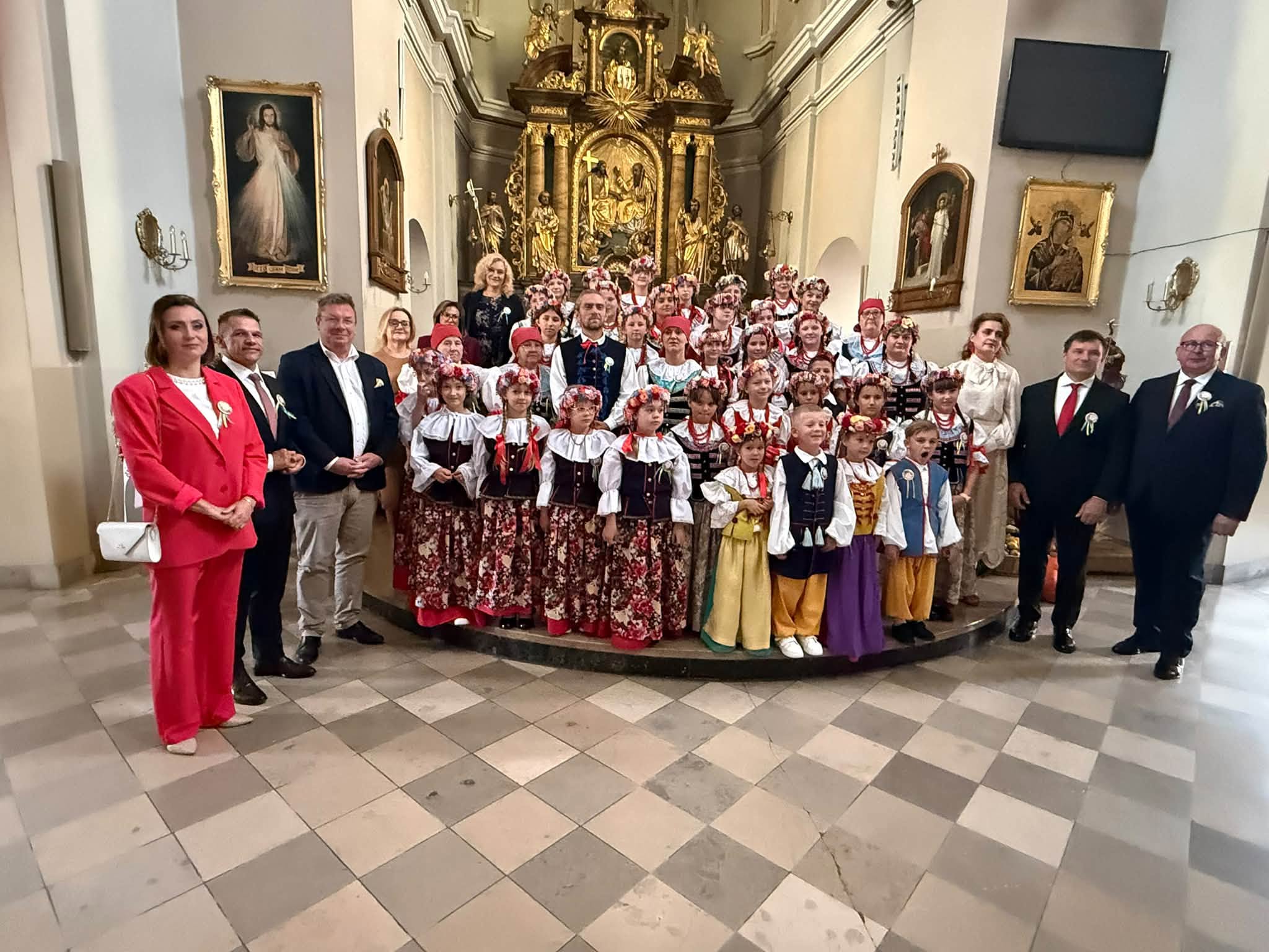 Osoby pozujące do zdjęcia w strojach śląskich w Kościele