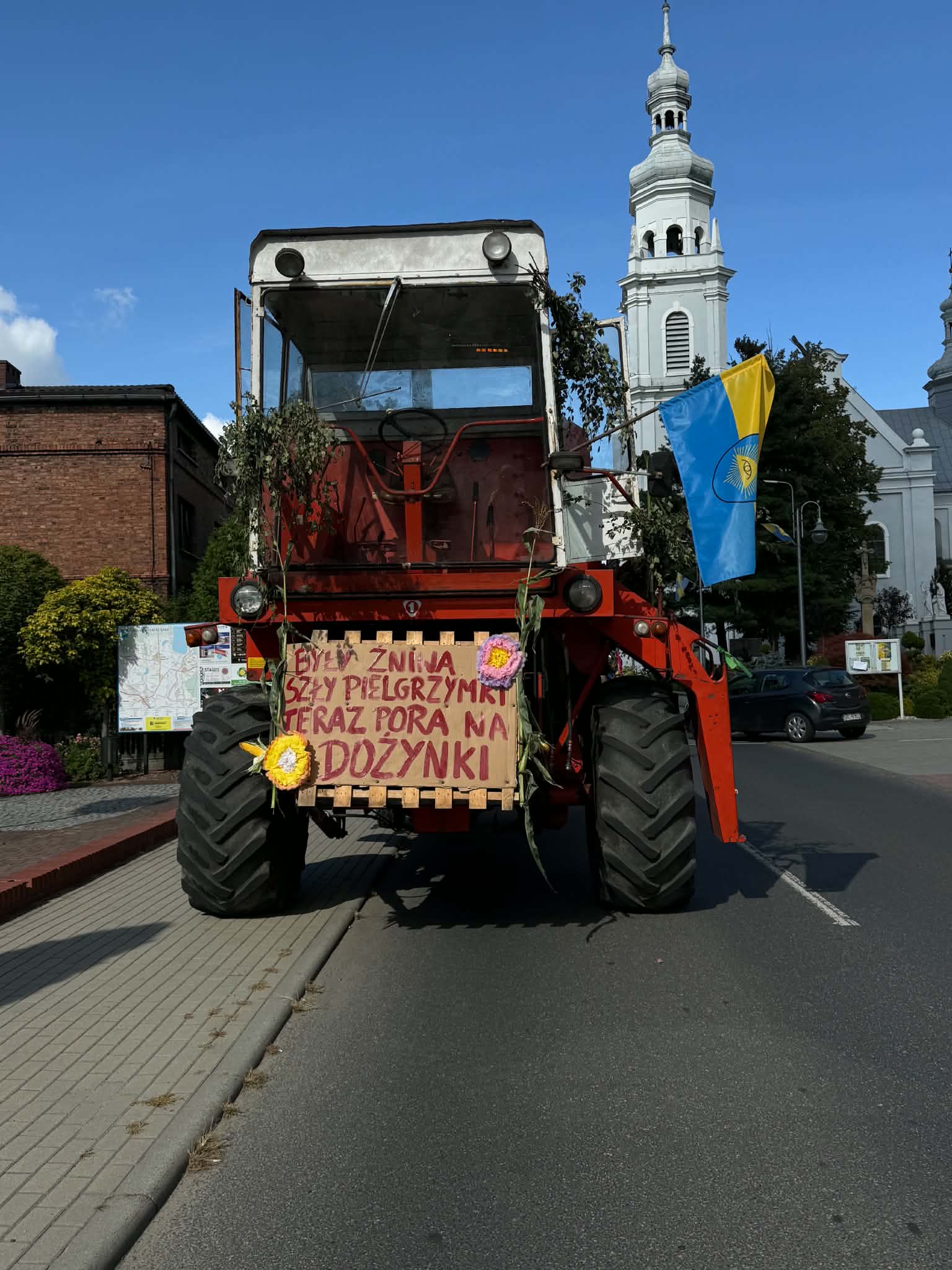 Kolorowy kombajn przed kościołem 