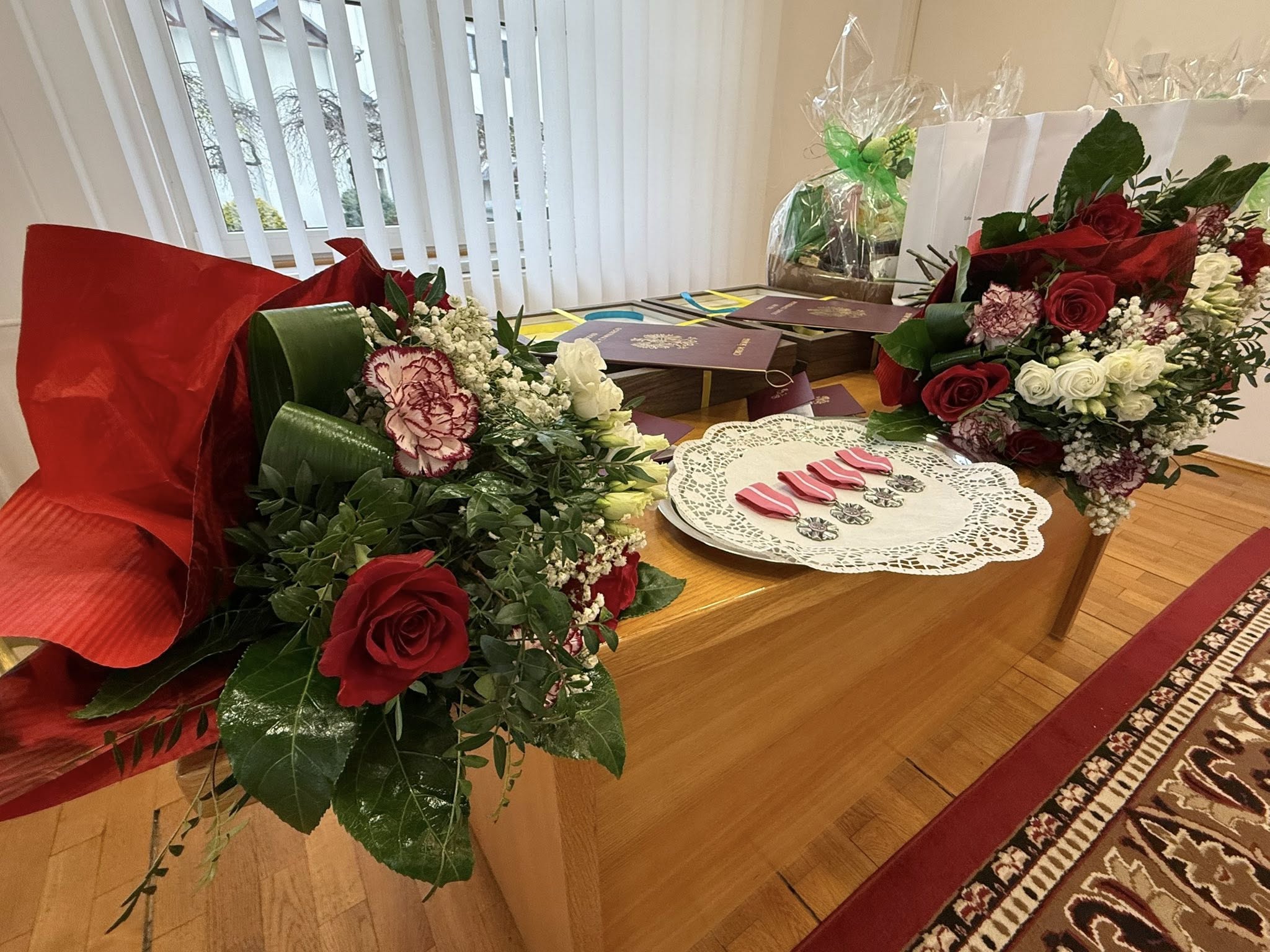 Medale, kwiaty i prezenty znajdujące się na biurku 