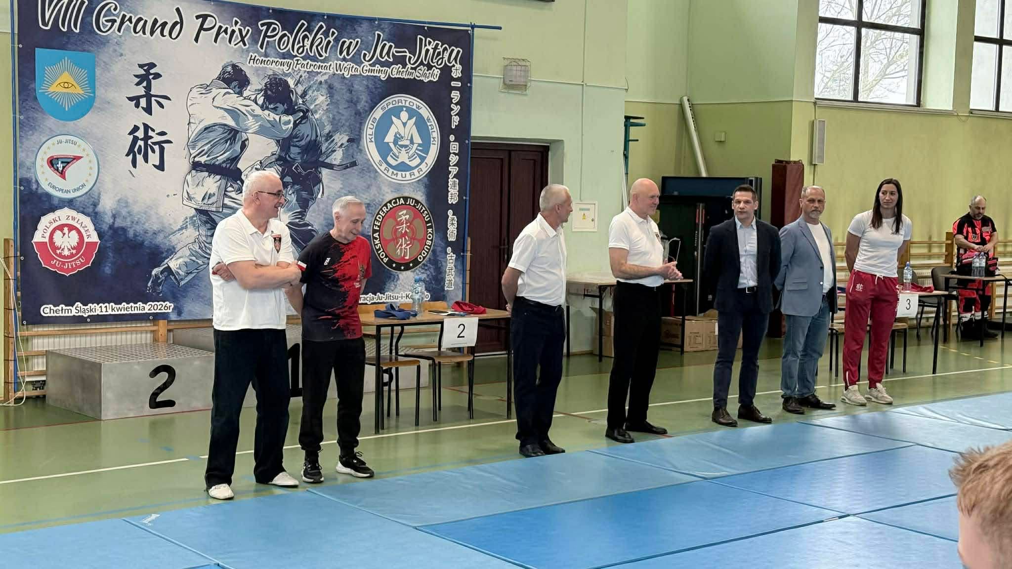 Osoby pozujące do zdjęcia w sali gimnastycznej - rozpoczęcie zawodów 
