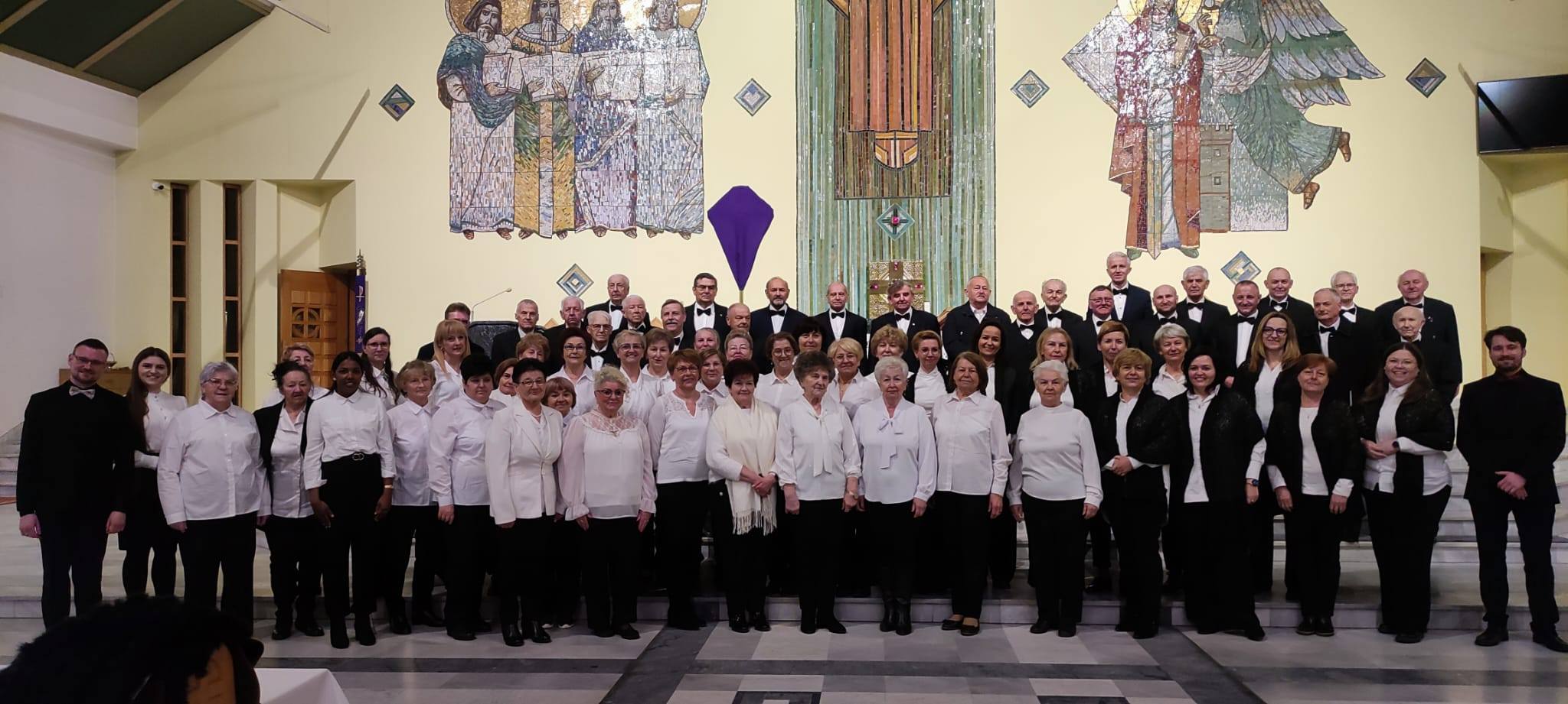 Kobioety i mężczyźni pozujący do zdjęcia w kościele na tle ołtarza