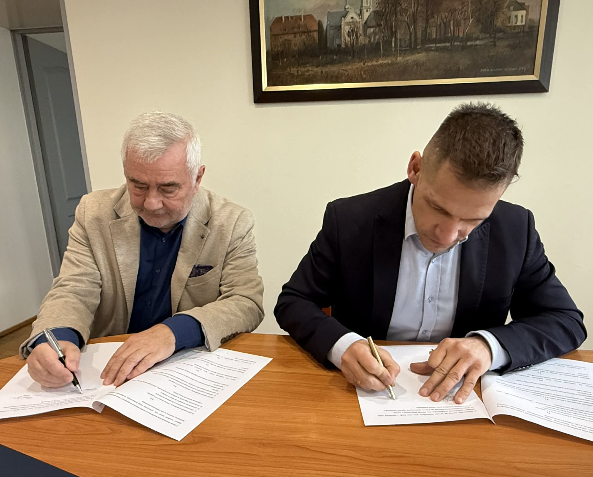 Dwóch mężczyznpodpisujących porozumienie o współpracy 