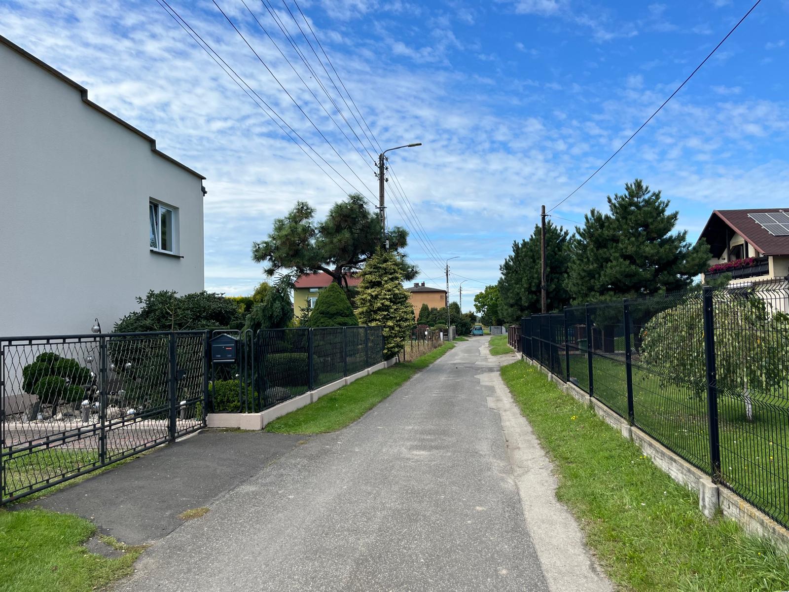 Ulica z infrastrukturą przebiagająca pomiędzy domami 