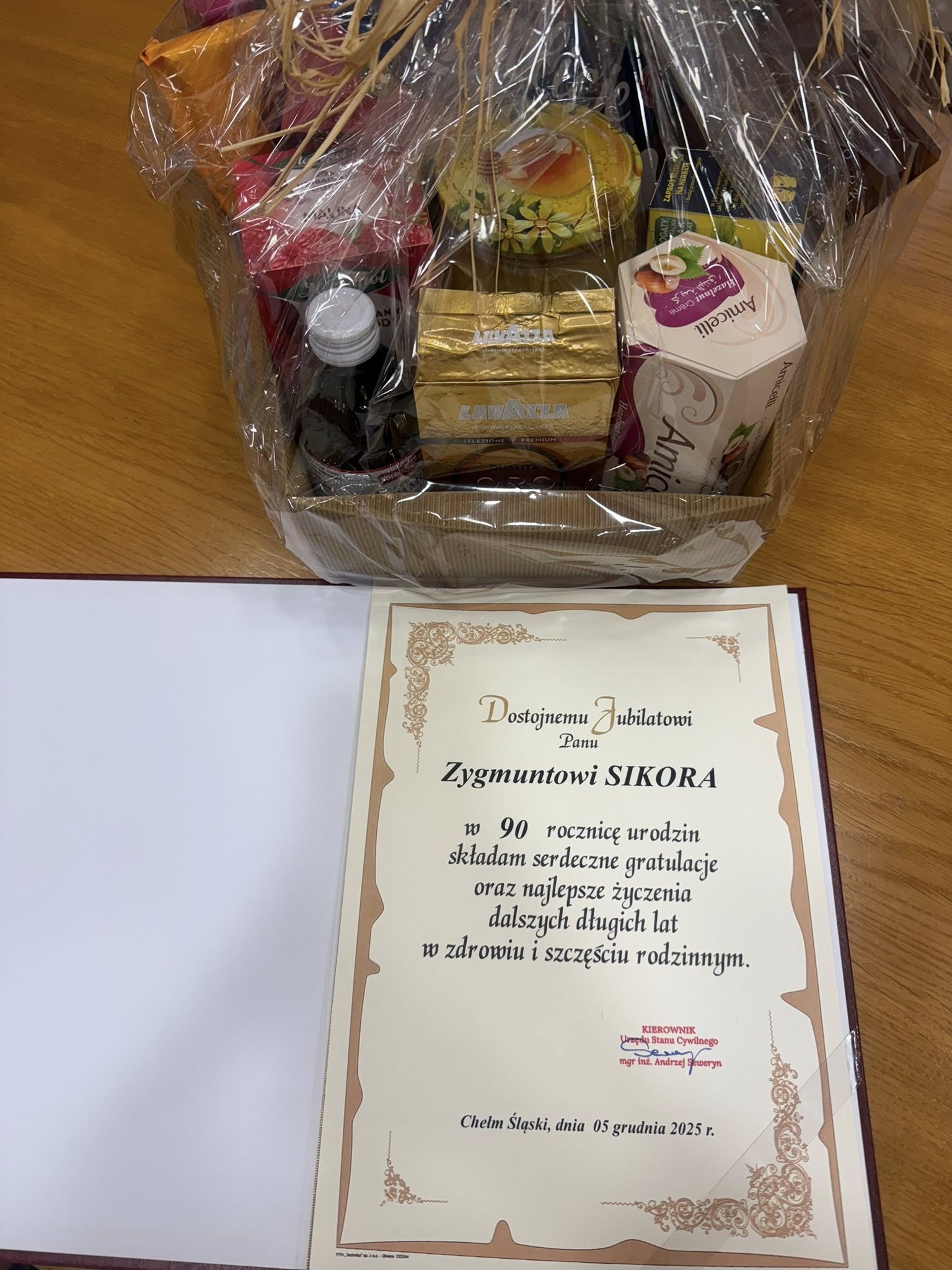 Dyplom z gratulacjami i kosz słodkości. 