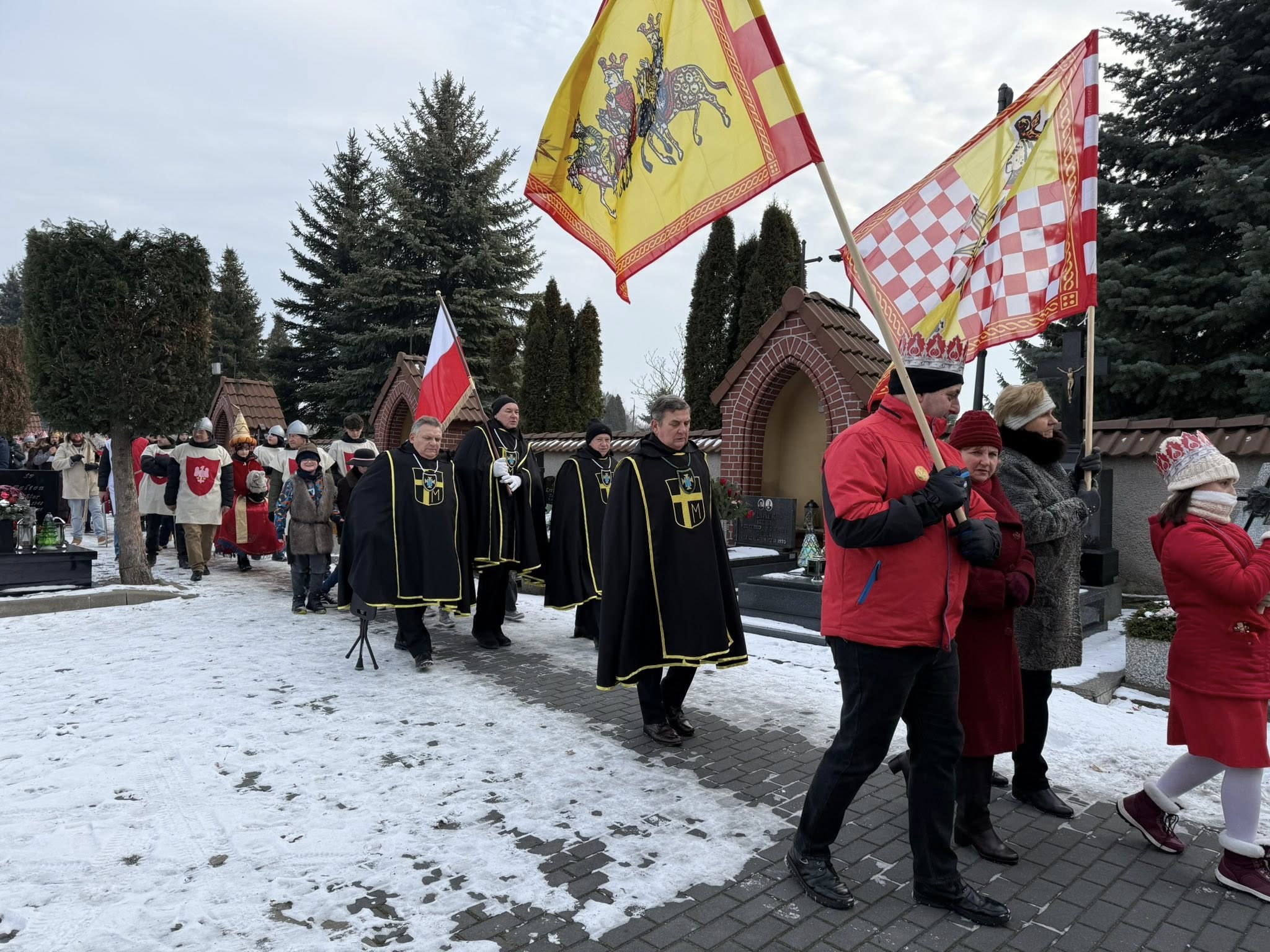 Mieszkańcy w strojach z flagami uczestniczacy w orszaku