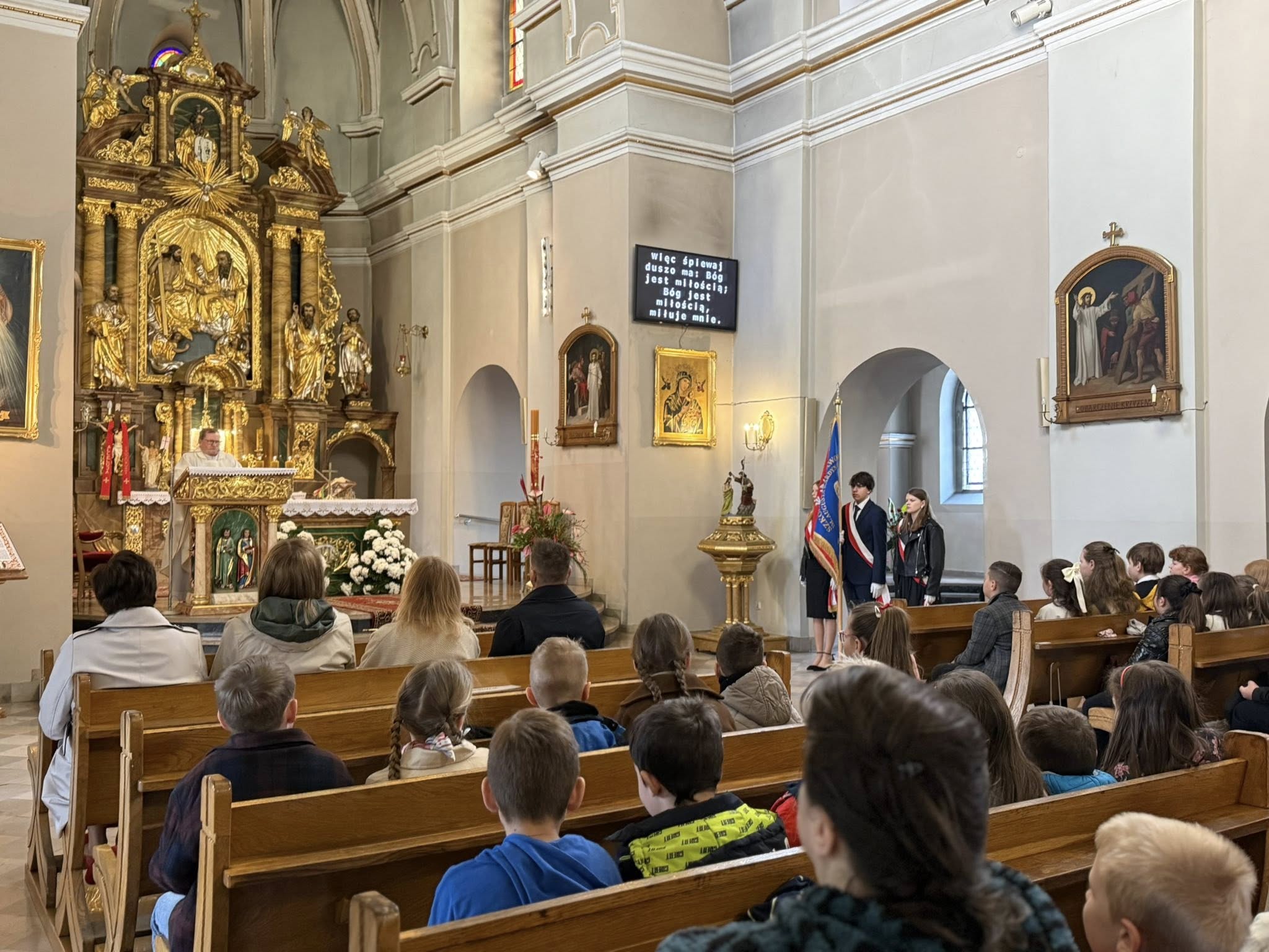 Zdjęcia ołtarza kościoła w ławkach siedzący ludzie. 