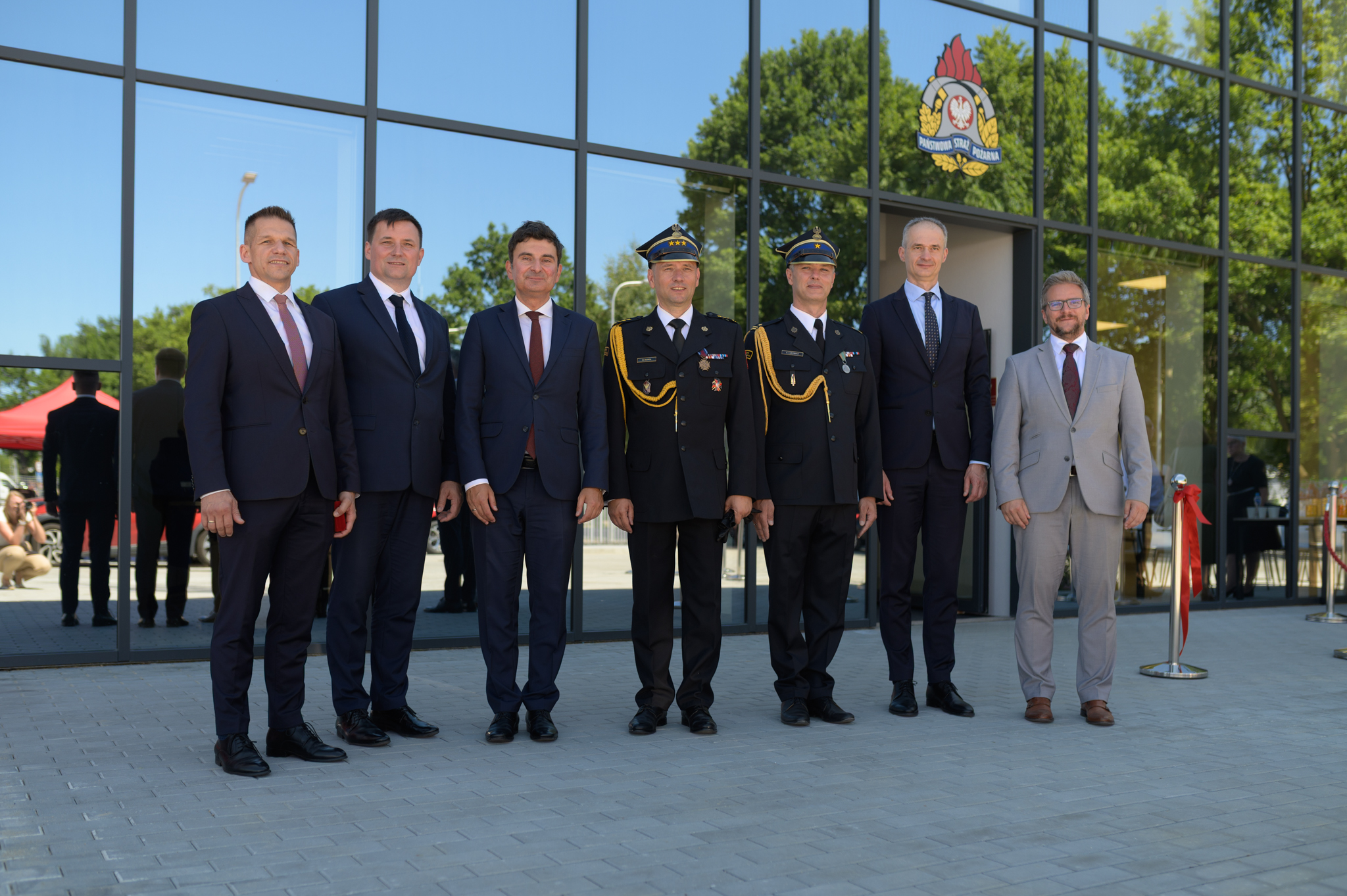 Mężczyźni pozujący do zdjęcia przed budynkiem 