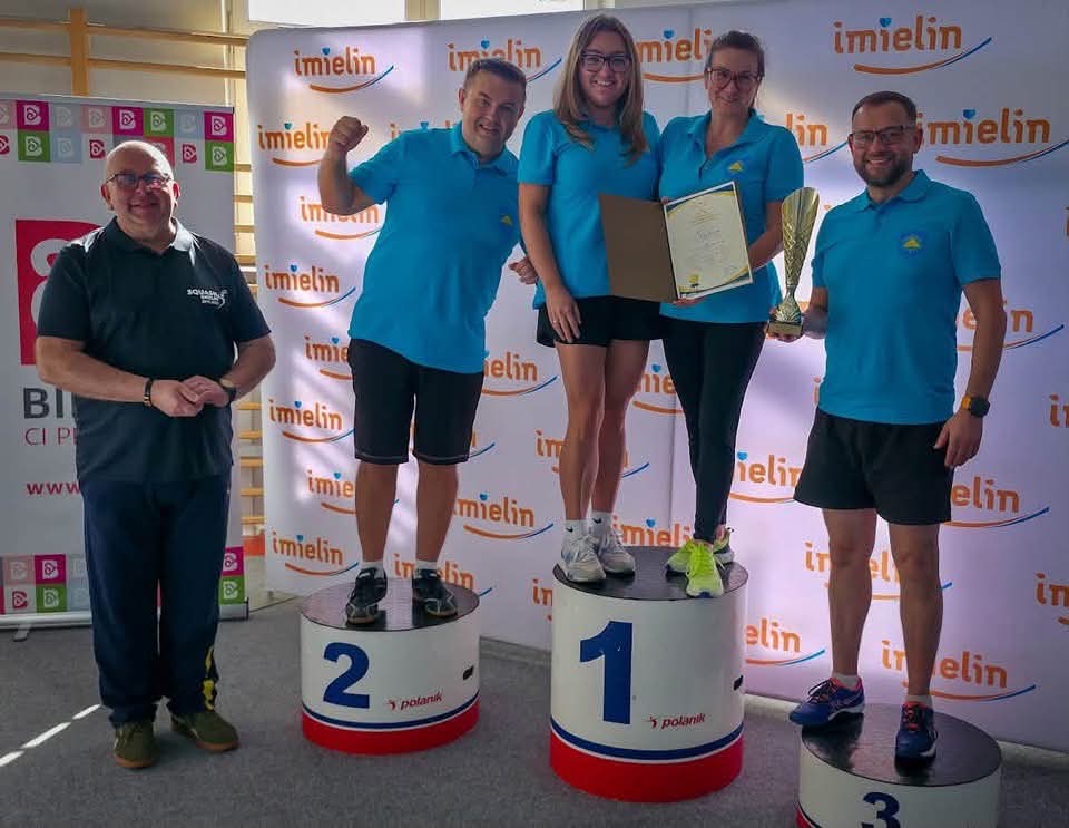 Trzech mężczyzn i dwie kobiety na podium