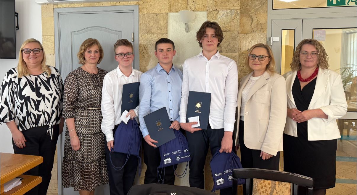 Uczniowie pozujący do zdjecia w sali sesujnej urzedu gminy Chełm Śląski 