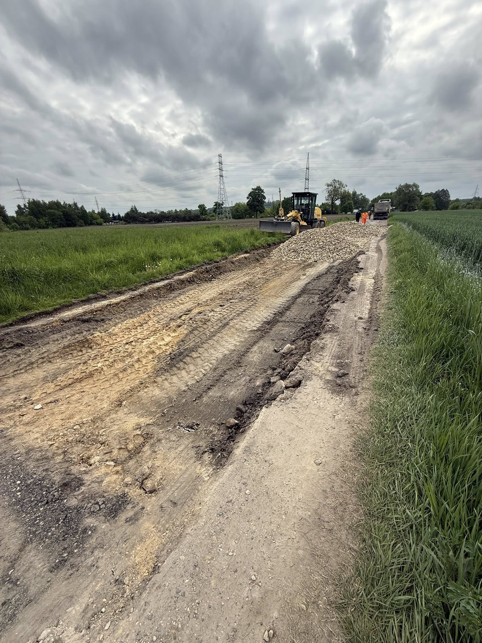 Budowa drogi. Na zdjęciu koparki i pracownicy na powstającej drodze 