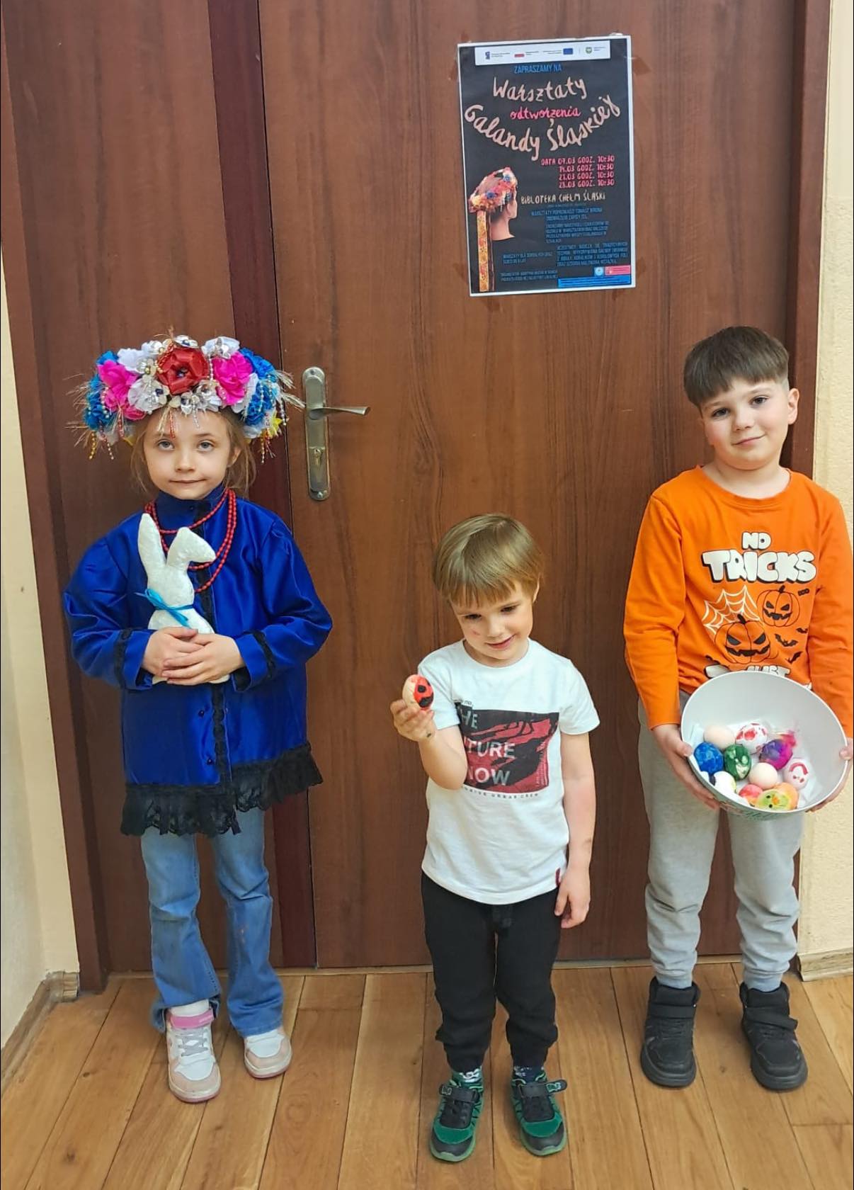 Dzieci pozujące do zdjęcia z pisankami i w galandzie śląskiej 