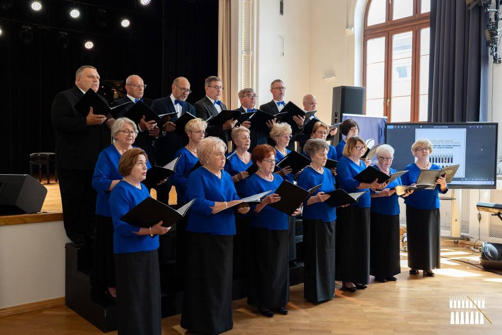 Osoby stojące w pomieszczeniu i śpiewające 
