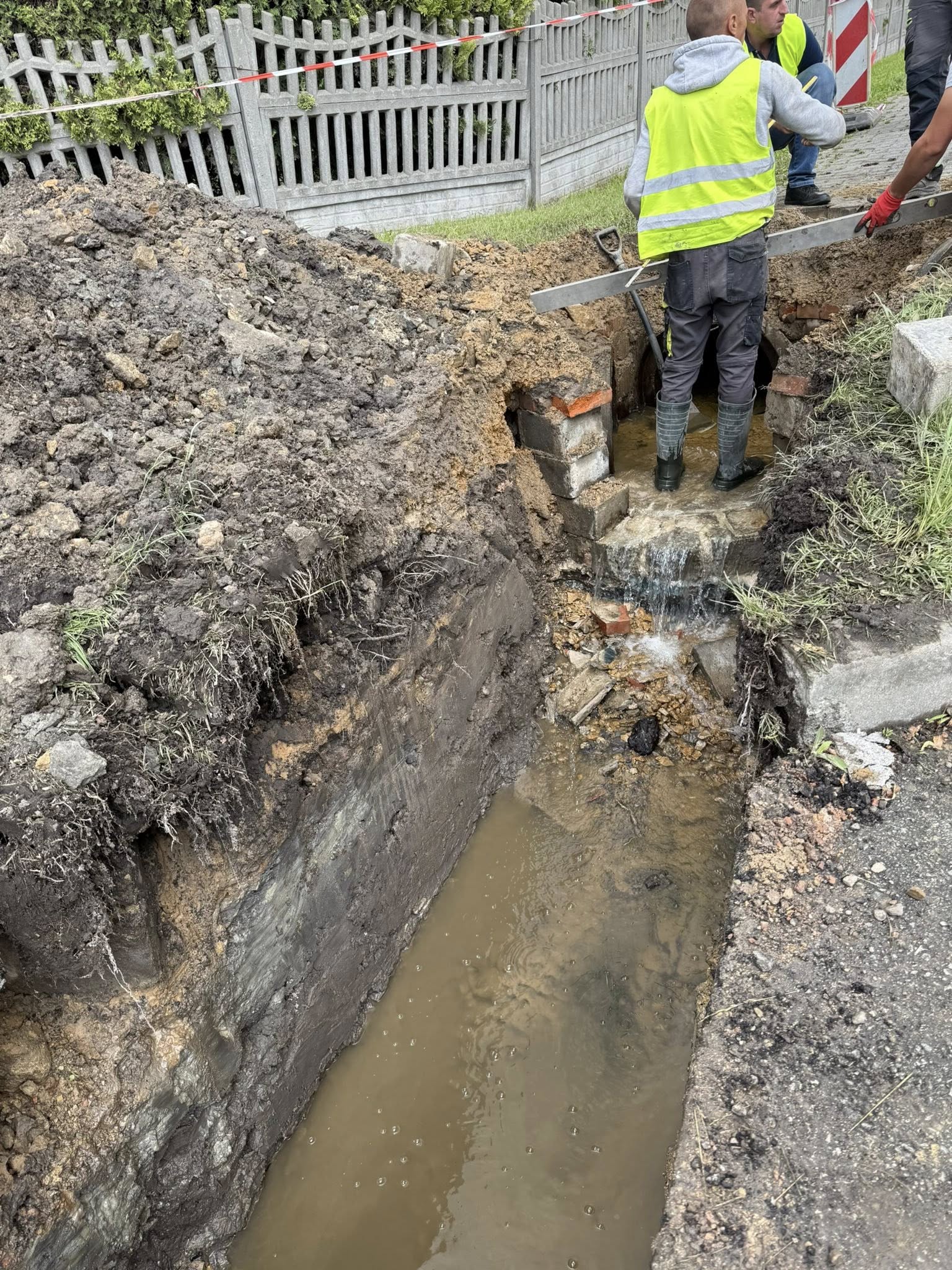 Mężczyzna stojący w wykopanym rowie 