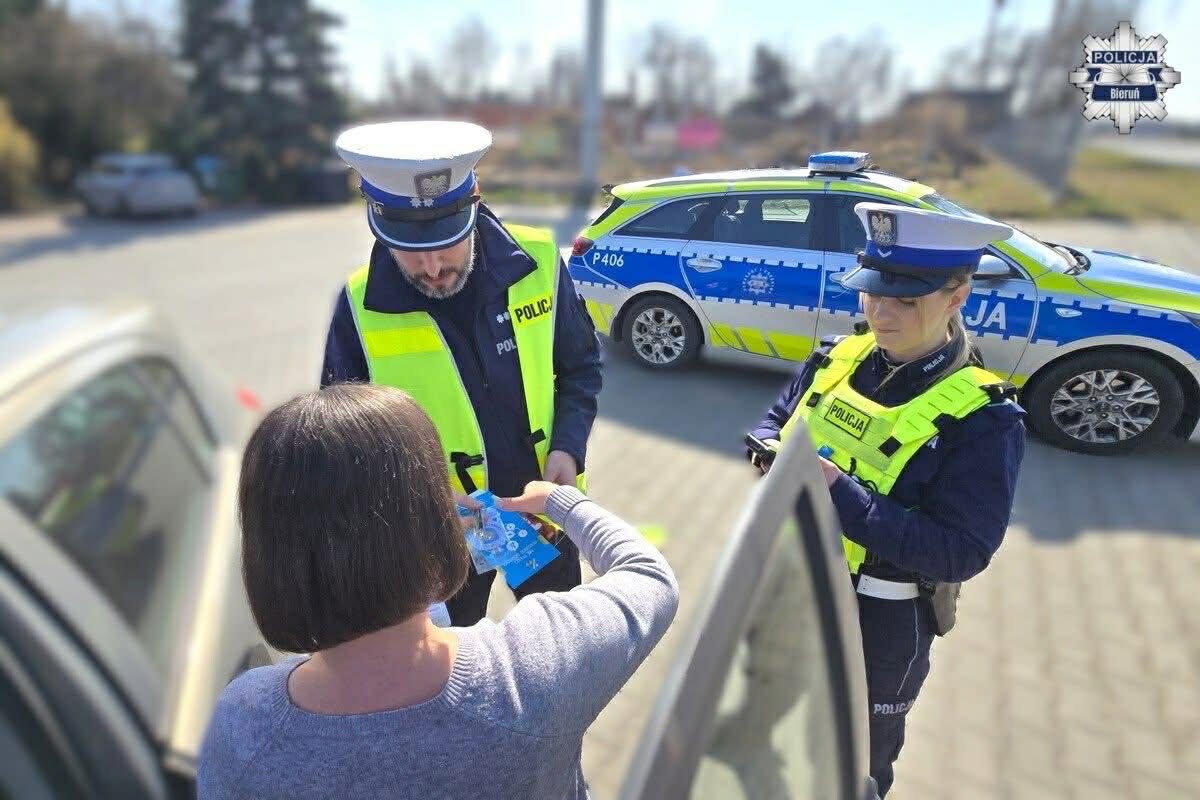 Kontrola policyjna na drodze. Dwóch funcjonariuszy policji i osoba kontrolowana 
