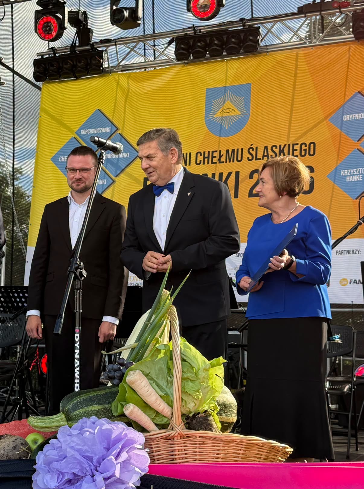 Trzy osoby na scenie plenerowej 