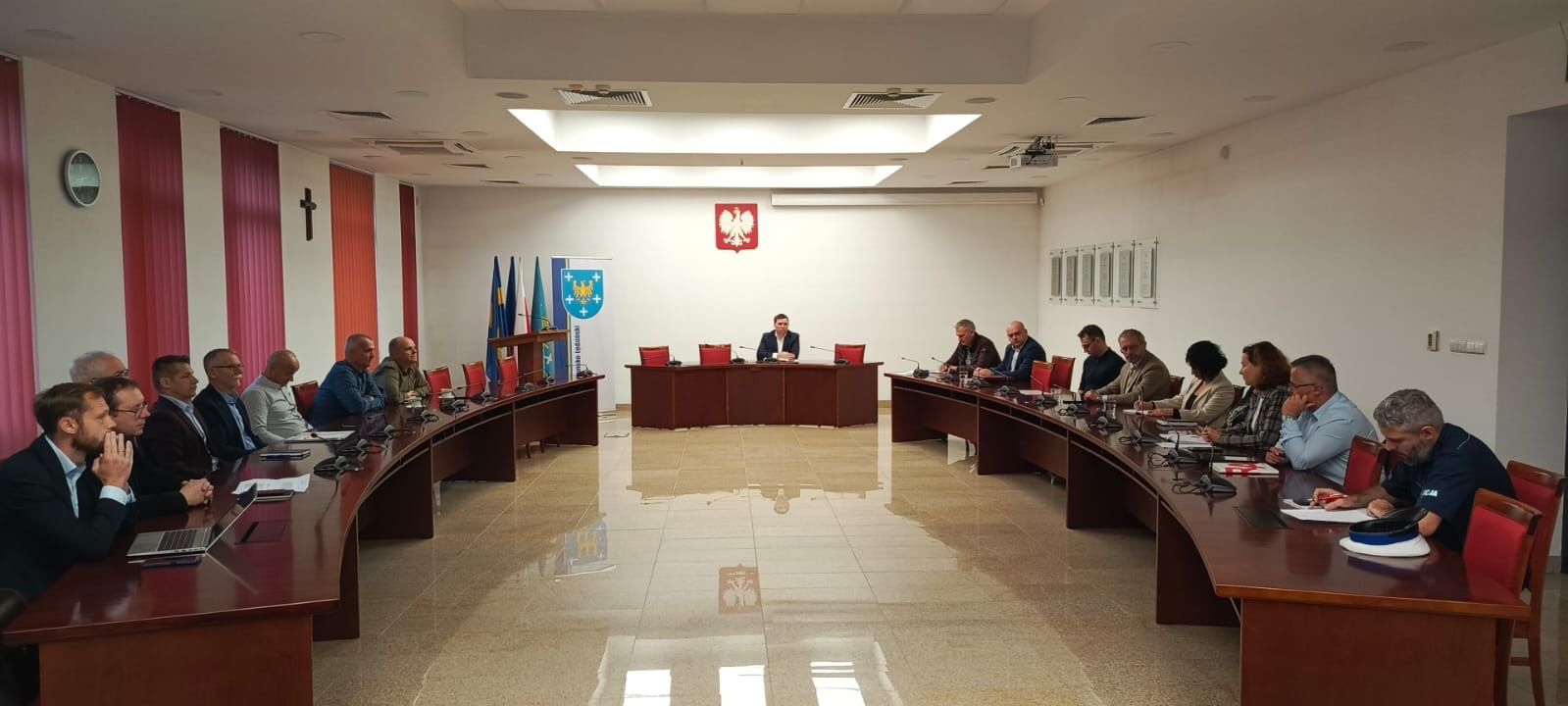 Osoby siedzące w sali narad 